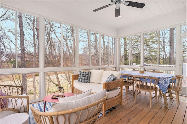 sunroom featuring outdoor dining area, ceiling fan, and an outdoor hangout area