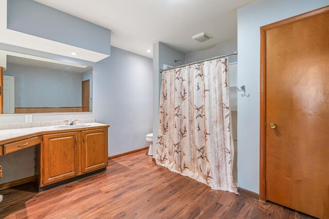 11886 Riverside Dr, White Pigeon, MI 49099 - full bath with wood finished floors, vanity, curtained shower, baseboards, and toilet