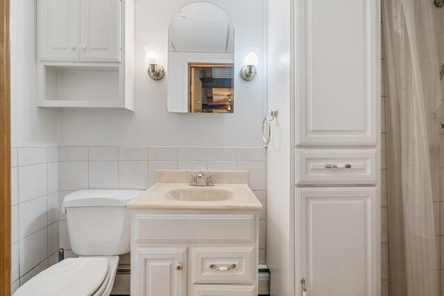 11886 Riverside Dr, White Pigeon, MI 49099 - bathroom with tile walls, toilet, vanity, and wainscoting