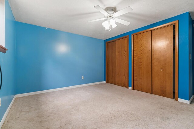 11886 Riverside Dr, White Pigeon, MI 49099 - unfurnished bedroom with two closets, ceiling fan, baseboards, and carpet