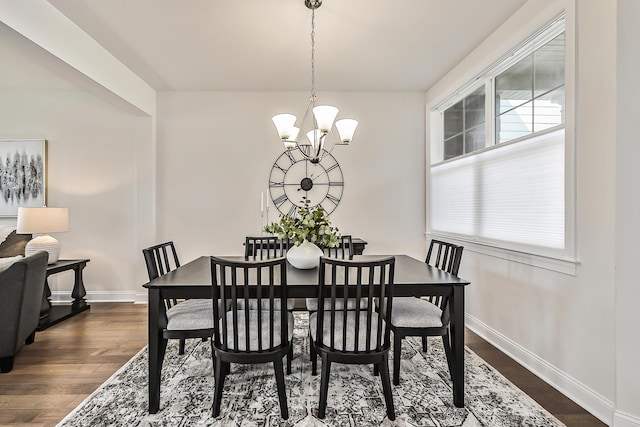 dining space featuring a chandelier, baseboards, and dark wood-style floors