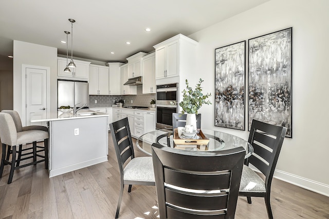 dining room with baseboards, recessed lighting, and light wood-type flooring