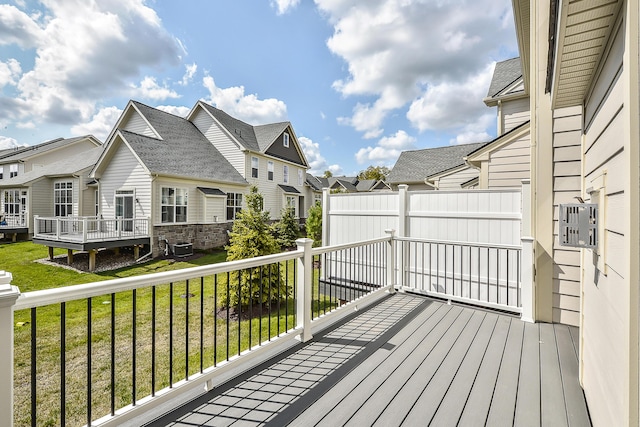 wooden terrace with a residential view and a lawn