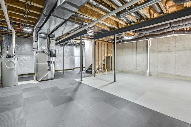 unfinished below grade area with water heater, tile patterned floors, heating unit, and stairs