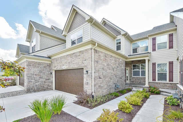 view of front of house with a garage, stone siding, and concrete driveway