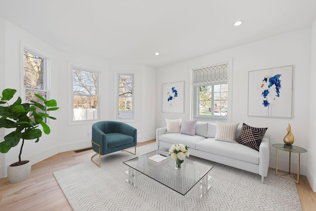 living area with baseboards, wood finished floors, and recessed lighting