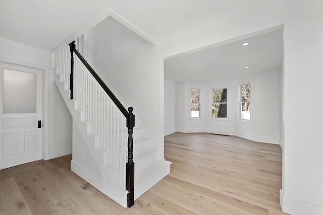 stairs with recessed lighting, wood finished floors, and baseboards
