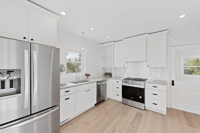 kitchen featuring decorative backsplash, a sink, white cabinetry, and appliances with stainless steel finishes