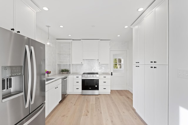 kitchen featuring white cabinets, light wood-type flooring, and appliances with stainless steel finishes