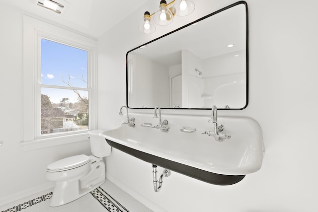 bathroom featuring a sink, toilet, visible vents, baseboards, and tile patterned flooring
