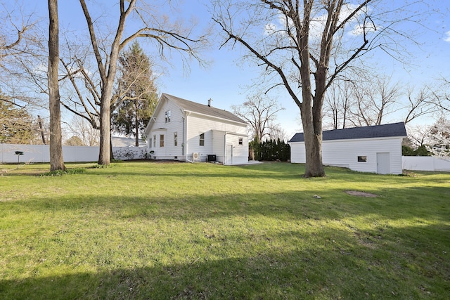 view of yard with fence and an outbuilding