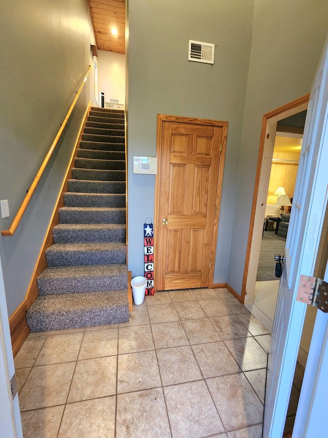 6039 W Morris Lake Rd, Mears, MI 49436 - stairway featuring baseboards, tile patterned floors, a towering ceiling, and visible vents