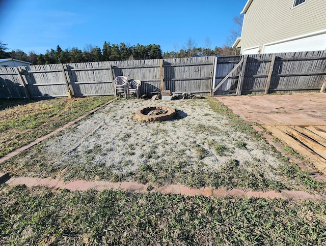 6039 W Morris Lake Rd, Mears, MI 49436 - view of yard featuring a fenced backyard, an outdoor fire pit, and a gate