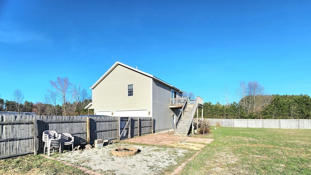 6039 W Morris Lake Rd, Mears, MI 49436 - exterior space featuring stairway, an outdoor fire pit, a fenced backyard, a yard, and a wooden deck