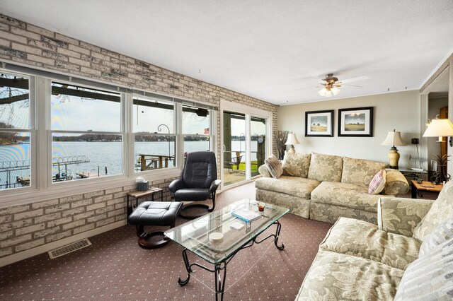 5505 Lakewood Dr, Coloma, MI 49038 - carpeted living area with brick wall, visible vents, and a wealth of natural light