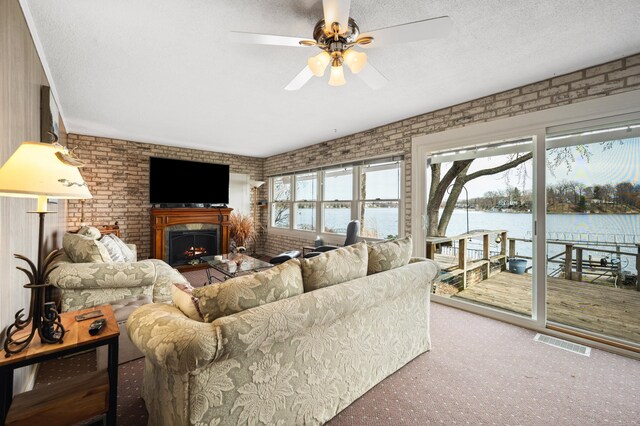5505 Lakewood Dr, Coloma, MI 49038 - living area featuring brick wall, carpet floors, a ceiling fan, and visible vents