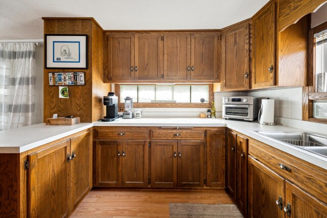 5505 Lakewood Dr, Coloma, MI 49038 - kitchen with light wood finished floors, a peninsula, light countertops, and brown cabinets
