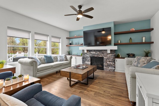 5849 Gavin Ln, Kalamazoo, MI 49009 - living area featuring a stone fireplace, ceiling fan, and wood finished floors