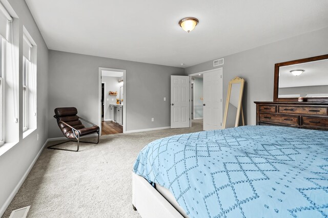 5849 Gavin Ln, Kalamazoo, MI 49009 - carpeted bedroom featuring baseboards, ensuite bathroom, and visible vents