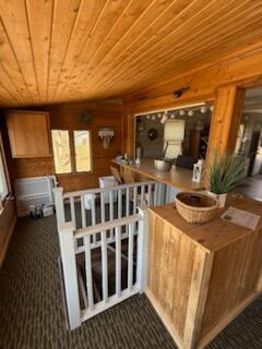 4605 Hunters Trl, Six Lakes, MI 48886 - bar area featuring wood ceiling and dark carpet