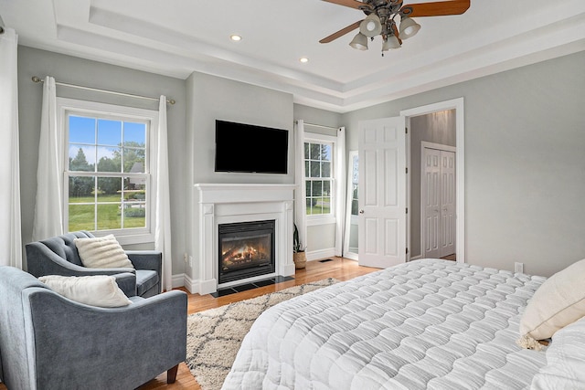 7812 Fountain Hills Ln, Davisburg, MI 48350 - bedroom with a raised ceiling, wood finished floors, recessed lighting, a fireplace with flush hearth, and baseboards