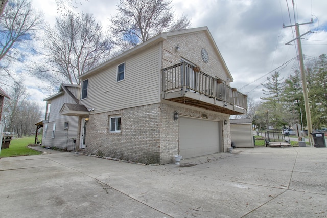 4790 Downing Dr, Pinckney, MI 48169 - rear view of property featuring brick siding, a balcony, a garage, and concrete driveway