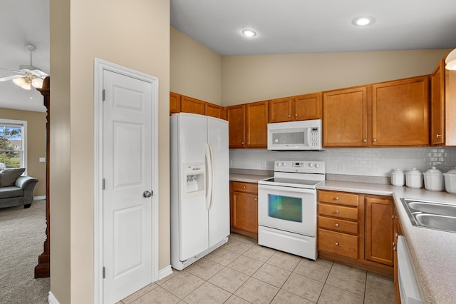 51441 Jordan St, Paw Paw, MI 49079 - kitchen with white appliances, ceiling fan, decorative backsplash, brown cabinetry, and light countertops