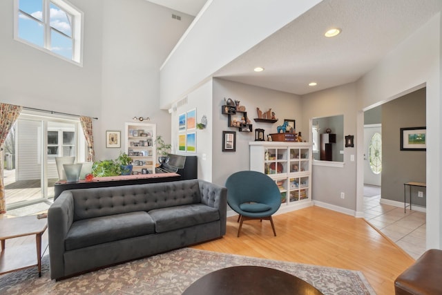 living room with recessed lighting, wood finished floors, visible vents, and baseboards