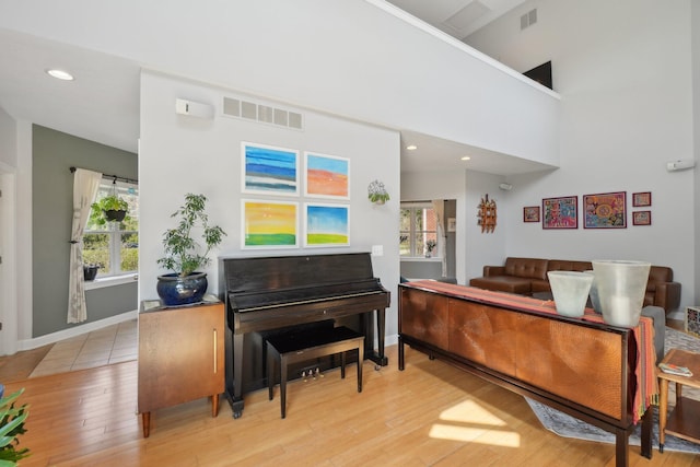 sitting room featuring visible vents, light wood finished floors, and a healthy amount of sunlight