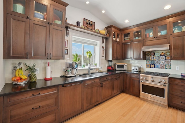 kitchen featuring a sink, dark countertops, recessed lighting, range hood, and high end range