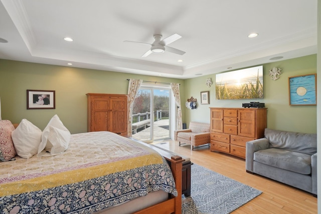bedroom with recessed lighting, a tray ceiling, a ceiling fan, light wood-type flooring, and access to outside