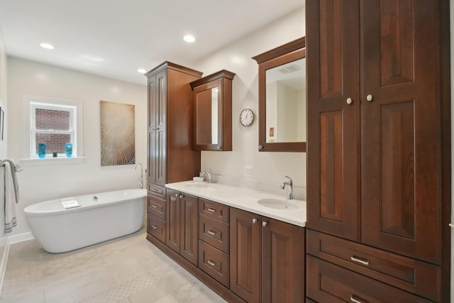 bathroom with a soaking tub, a sink, double vanity, and recessed lighting