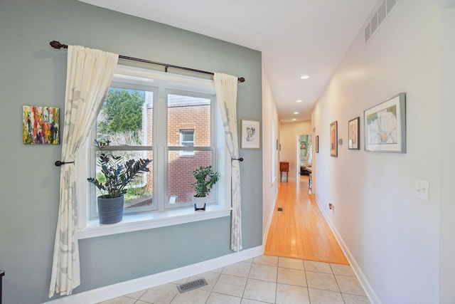 hallway featuring recessed lighting, visible vents, baseboards, and light tile patterned floors
