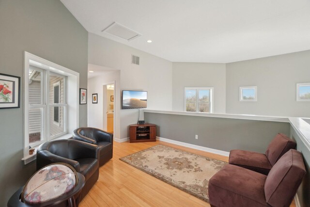living area with attic access, visible vents, recessed lighting, baseboards, and wood finished floors
