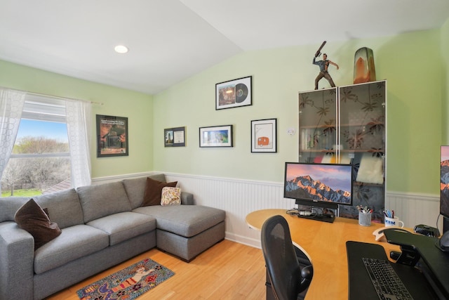 office area with wainscoting, wood finished floors, and lofted ceiling