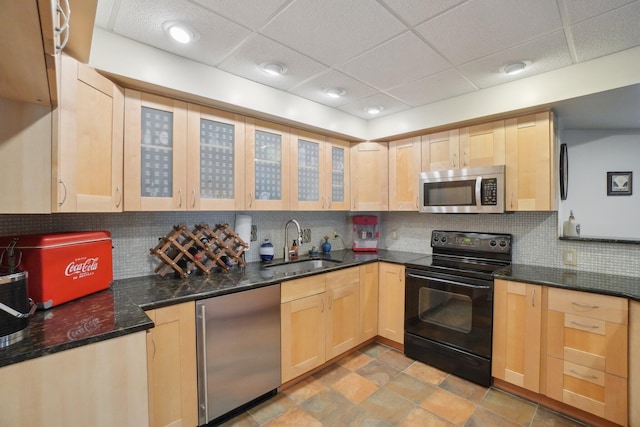 kitchen featuring a sink, stainless steel microwave, black range with electric cooktop, light brown cabinets, and refrigerator