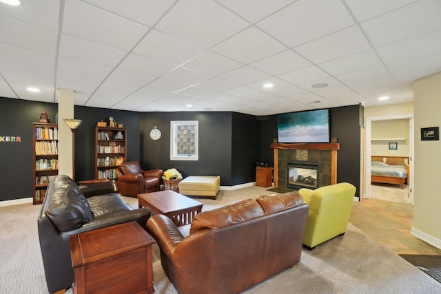 living area featuring a drop ceiling, a tile fireplace, carpet, baseboards, and recessed lighting