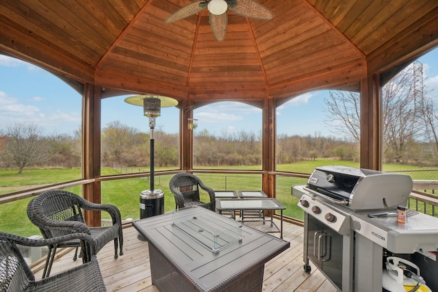 wooden deck featuring grilling area, a gazebo, a yard, and ceiling fan
