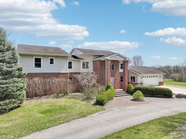 view of front facade featuring a garage, brick siding, a front yard, and concrete driveway