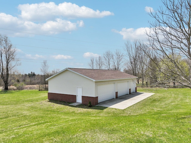 view of side of home featuring a lawn, an outbuilding, brick siding, and a garage