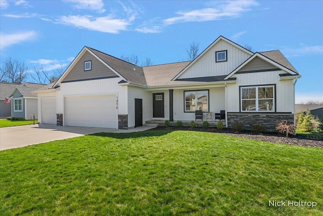 view of front facade featuring an attached garage, stone siding, a front yard, and concrete driveway