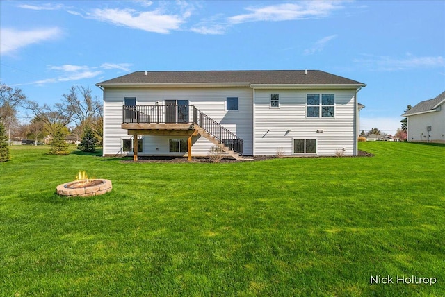 rear view of house featuring a lawn, an outdoor fire pit, stairs, and a deck