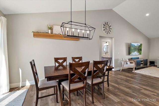 dining area featuring high vaulted ceiling, wood finished floors, baseboards, a notable chandelier, and recessed lighting