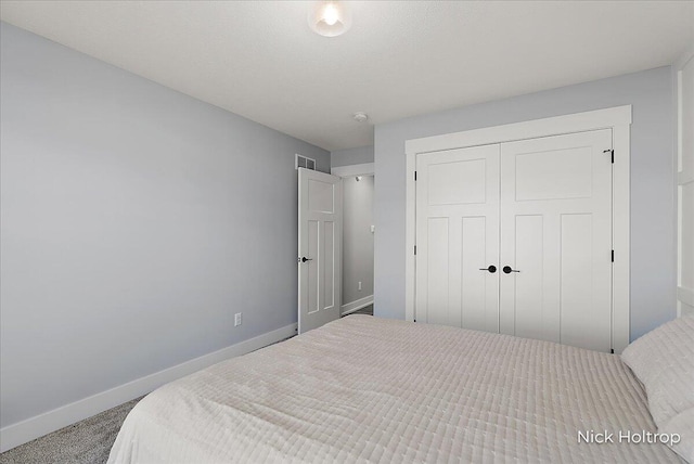 carpeted bedroom featuring baseboards, visible vents, and a closet