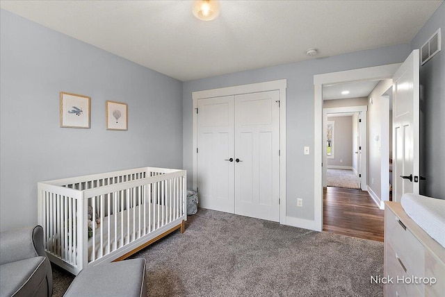 bedroom with baseboards, carpet floors, visible vents, and a closet