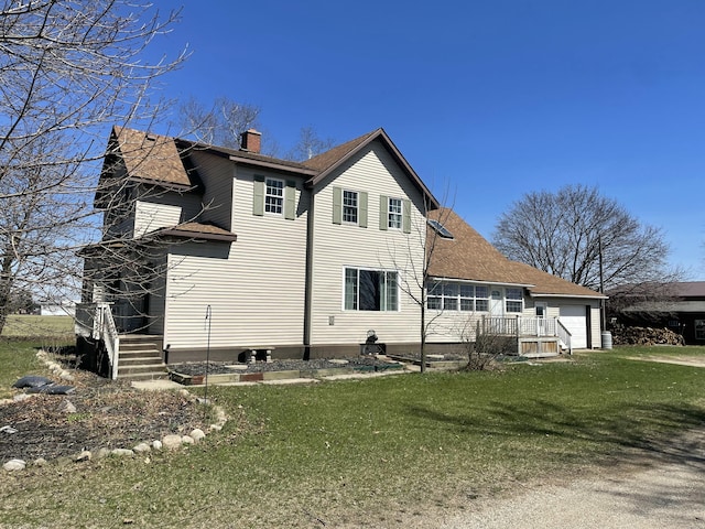 view of side of home featuring a chimney, a yard, and a shingled roof