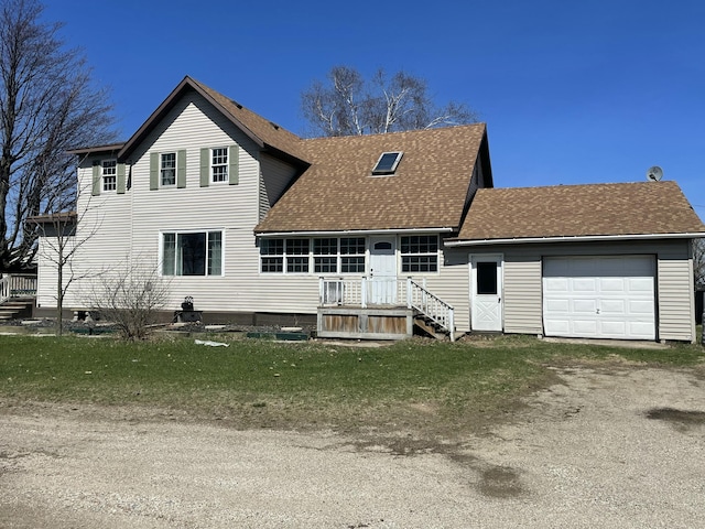 rear view of house featuring driveway, roof with shingles, and a garage