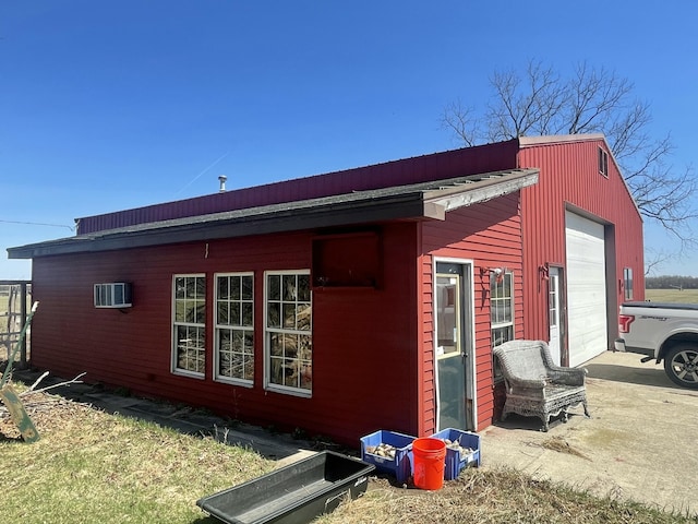 view of property exterior featuring an outdoor structure and an AC wall unit