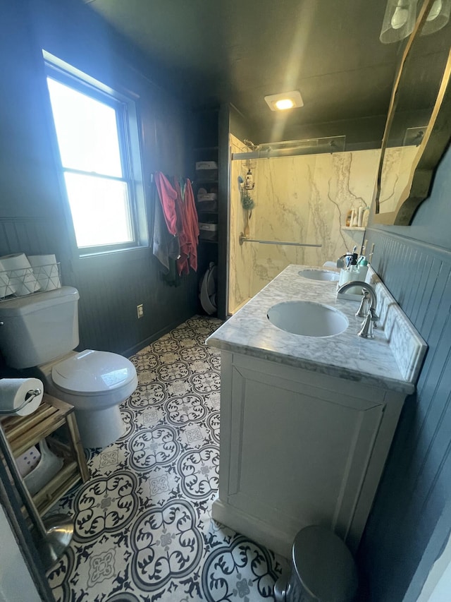 full bath featuring toilet, a sink, and double vanity