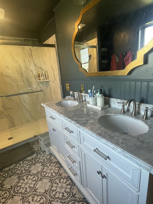 full bath featuring tile patterned floors, a sink, a shower stall, and double vanity